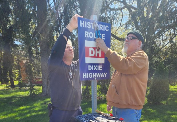 Phil Serviss, left, and John Maracic, members of the A's-R-Us Model A Ford club based in Crete, erect a new Dixie Highway sign in April along the route of the historic road in Crete. June's Day on the Dixie tour will raise money for maintenance and more signs along the route, Serviss said. (Phil Serviss)